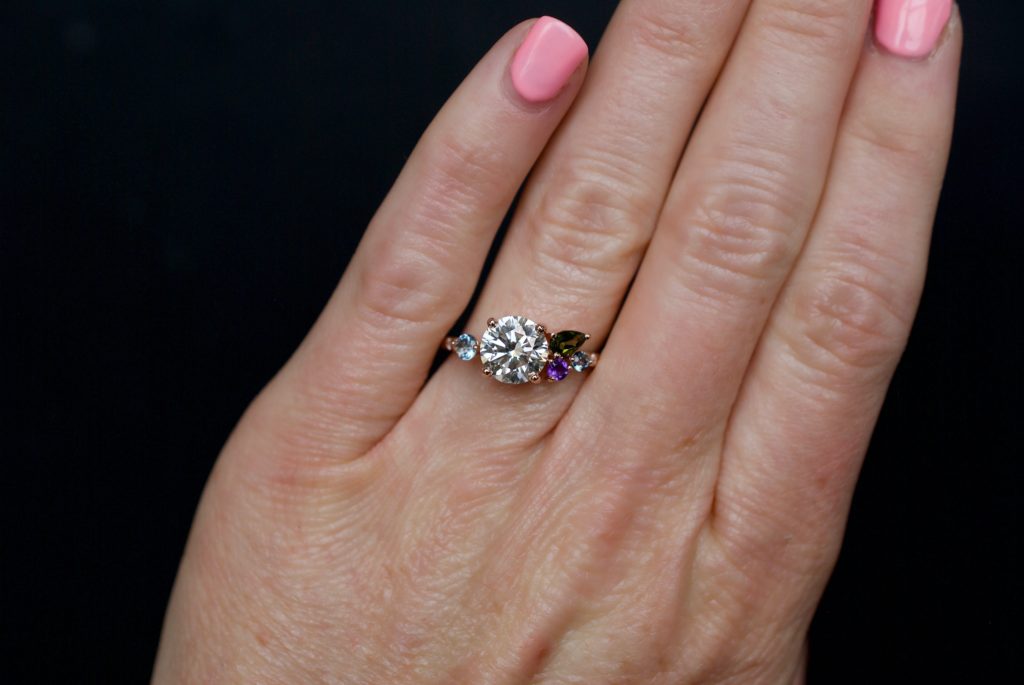 The Christie, 2 carat diamond and rose gold cluster engagement ring with aquamarine and tourmaline on a hand, by Fine Jewelry Designer Abby Sparks Jewelry.